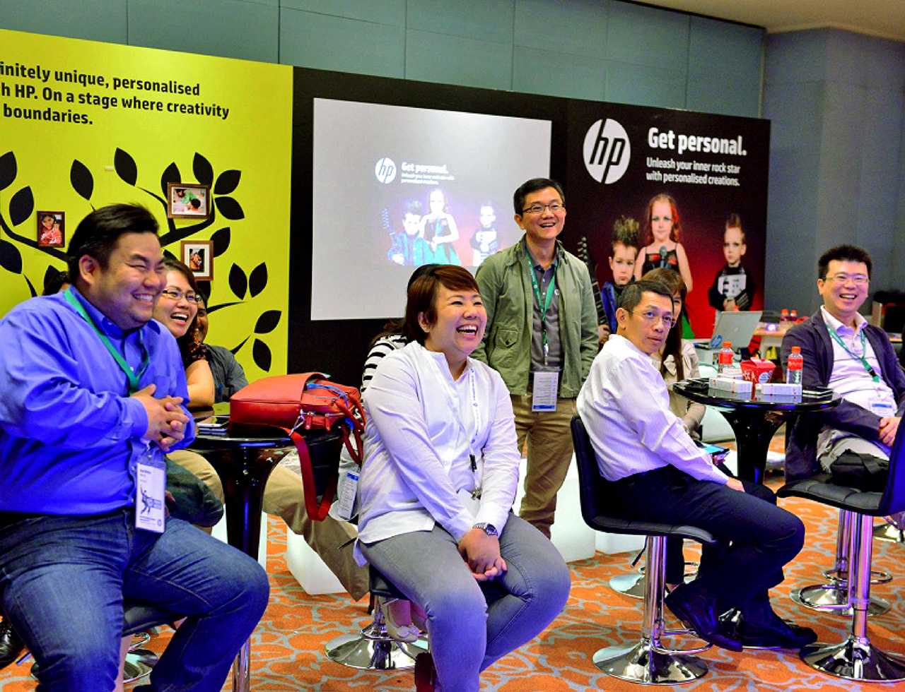 A group of highly engaged attendees at a conference booth