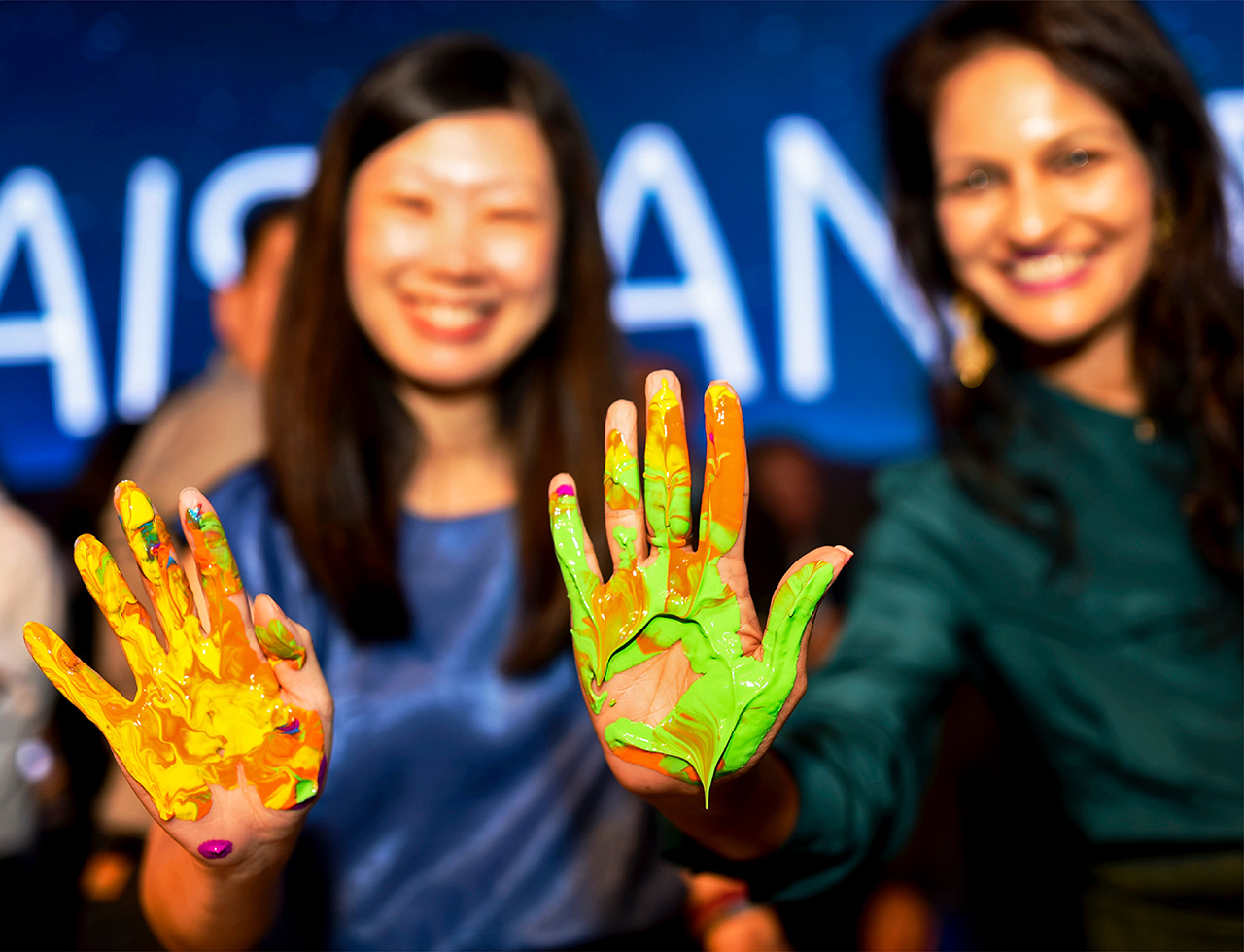 Happy business delegates, hands coated in paint, ready to leave their mark for a historic moment