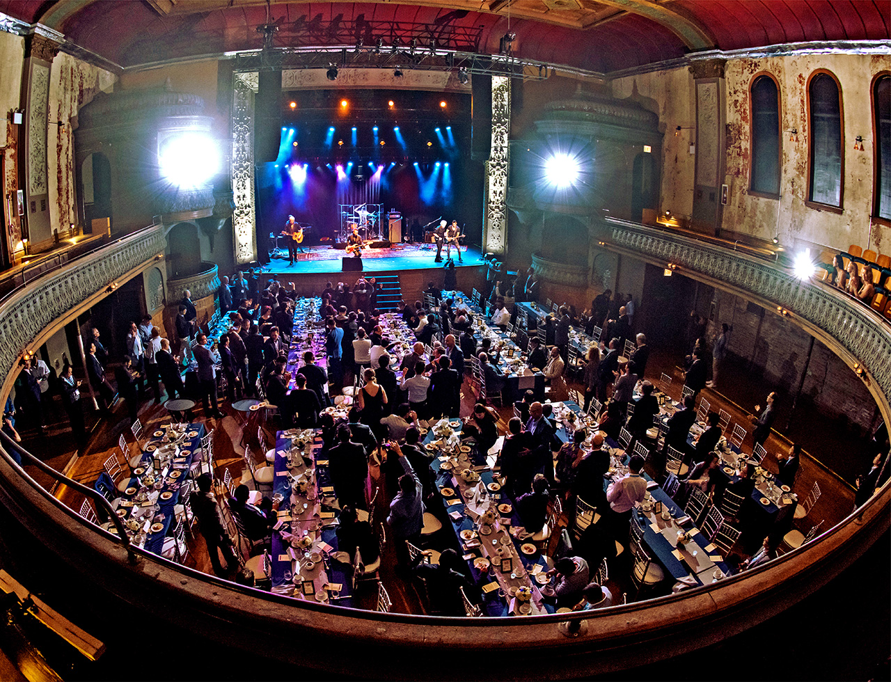 Business delegates enjoying live music performance during Gala dinner inside a concert hall in Chicago