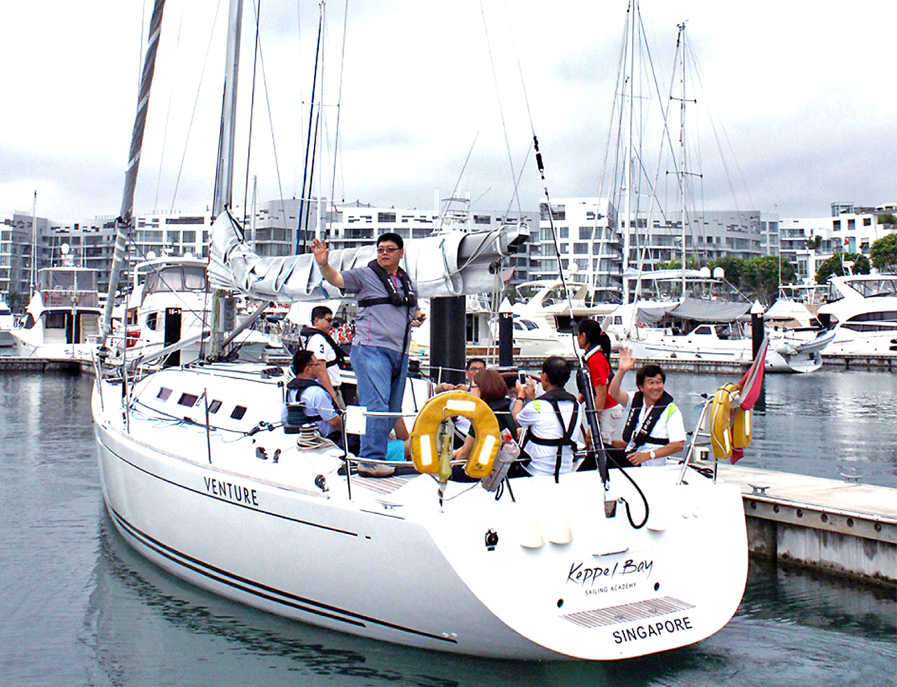 Business delegates engaging in fun yacht race for corporate teambuilding and networking