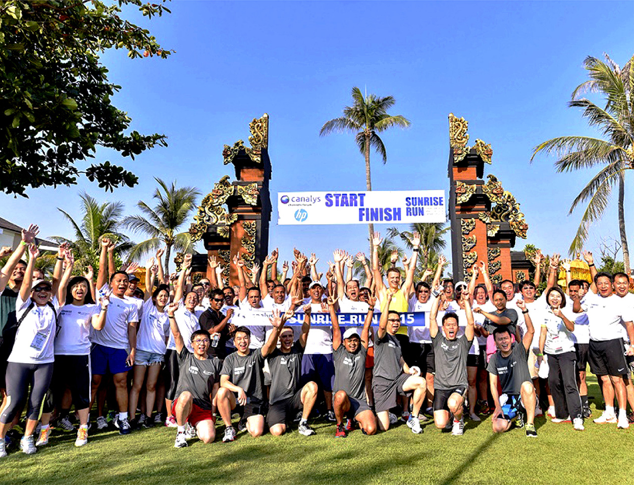 A large group of corporate delegates taking a group photo after a corporate race in Bali