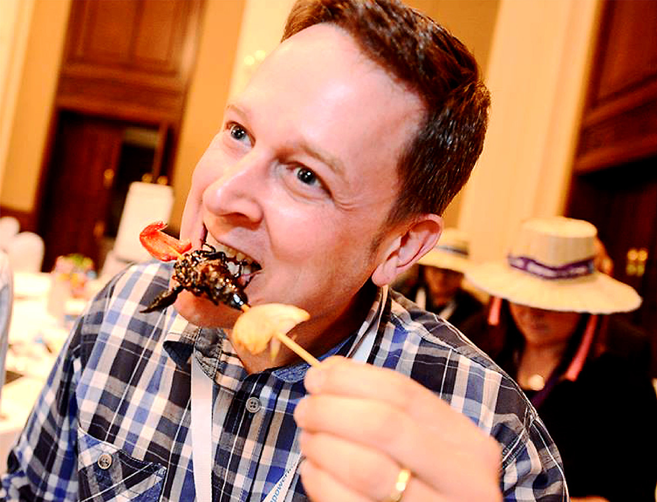 Man trying exotic local delicacy during a corporate teambuilding challenge