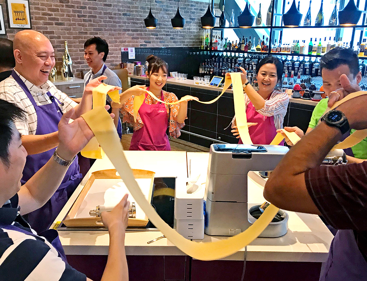 A team of people making dough during a culinary corporate teambuilding activity