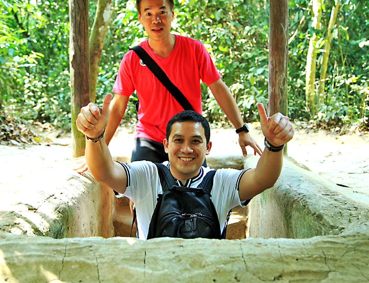 Man doing a thumbs up before entering the Cu Chi tunnel during a corporate teambuilding in Vietnam